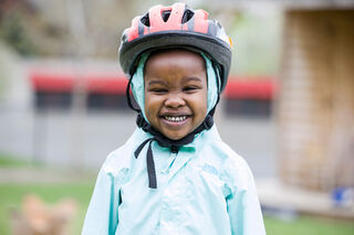 Picture of girl smiling with bicycle helmet on.