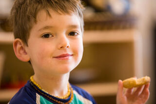 Picture of boy smiling with a cookie.